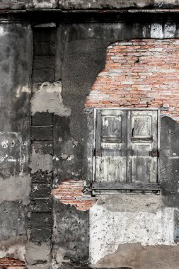 Antik evin eski tuğla duvar dokusu, soyut kaba, çatlak, aşınmış, hasarlı alçı ve eski ahşap pencere. Tam çerçeve.