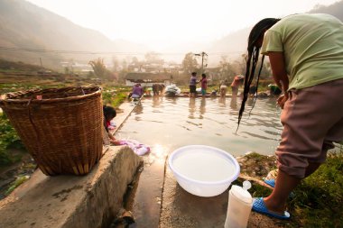 Bir grup Çinli kadın güneş doğarken antik bir köyde yıkanıp yıkanıyor. Güney Çin 'in Yunnan kentindeki kırsal kesimde..