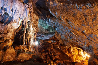 Büyük mağaranın içindeki mistik kireçtaşı mağarasını meşale, sihirli şekil ve sarkıt ve dikit dokusuyla keşfediyorlar. Nam Nao Ulusal Parkı, Tayland.