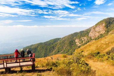 Bir grup turist dağların zirvesinde dinleniyor, kış sabahı manzarası çok güzel..