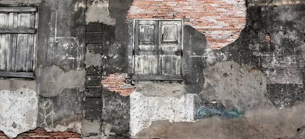 Antik evin eski tuğla duvar dokusu, soyut kaba, çatlak, aşınmış, hasarlı alçı ve eski ahşap pencere. Tam çerçeve.