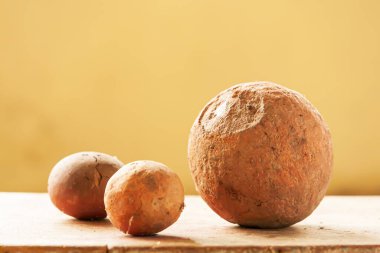 Antik çamur toplarının yakın plan çekimi ahşap masa üzerinde krem duvarda, antik çamur topları yerel Sing Buri, Tayland müzesinde sergilenmektedir. Müze halka açıktır..