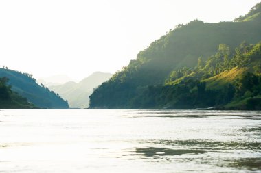 Sabahın erken saatlerinde Mekong Nehri 'nin sakin manzarası, nehirde gün doğumu ve nehir kıyısında tropikal orman. Kuzey Laos.