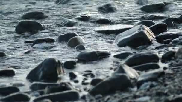 白天的最后一盏灯 用海浪沐浴的石头和鹅卵石 — 图库视频影像