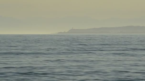 海波浪在海与山和塔灯塔在背景动 — 图库视频影像