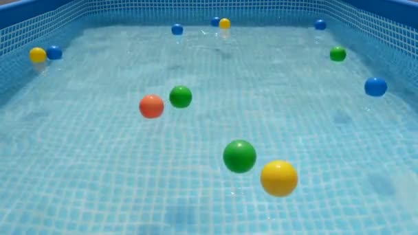 Bolas Diferentes Colores Flotando Agua Una Pequeña Piscina Verano — Vídeo de stock