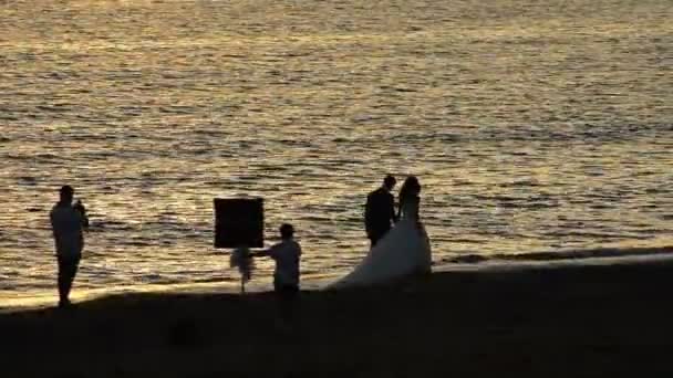 Fotograf Och Nygift Par Att Göra Bilder Stranden Vid Solnedgången — Stockvideo