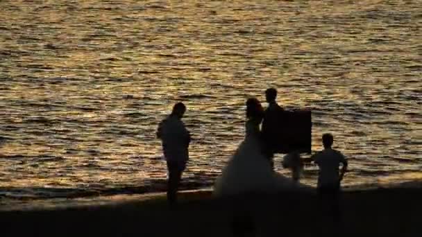 Fotograaf Jonggehuwde Paar Maken Van Foto Aan Kust Bij Zonsondergang — Stockvideo