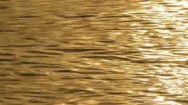 Gün batımında denizin dalgaları üzerinden güneşin altın düşünceler