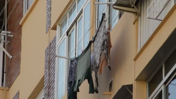 階建ての大きな建物のファサードの外乾燥する絞首刑の服 — ストック動画
