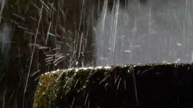 Arka ışık antik kaya çeşmede düşen su damlaları