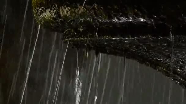 在背光的古老岩石喷泉中掉落和溢出的字体的水 — 图库视频影像