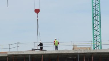 Crane inşaat halindeki bir binanın modülünü yerleştiriyor.