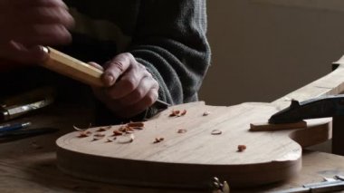 İşyerinde bir oymak ile yeni bir elektro gitar imalat luthier