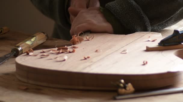 Geigenbauer Schnitzt Die Form Einer Neuen Gitarre Mit Hohlmeißel Arbeitsplatz — Stockvideo