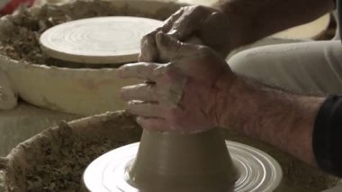 Potter ustası yeni bir vazoyu çamur ya da kille kaplıyor.