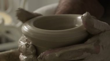 Potter craftsman molding on a new piece vase in mud or clay