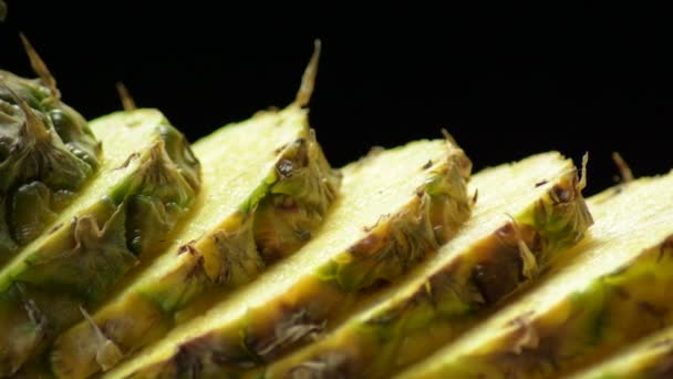 Tranches d'ananas gyroscopiques sur fond noir, studio 