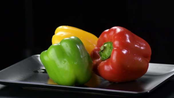 Pimentas Amarelas Vermelhas Verdes Legumes Girando Uma Bandeja Preta — Vídeo de Stock