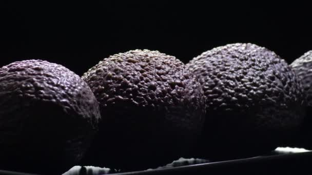 Skin Dark Violet Ripe Hass Avocado Fruit Gyrating Black Background — Stock Video