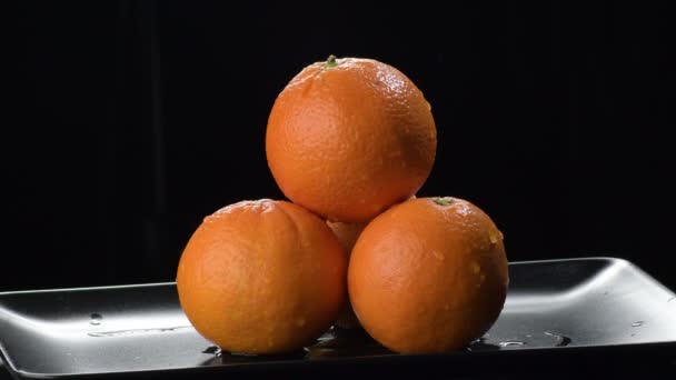 Naranjas Fruta Sobre Una Bandeja Negra Girando Sobre Fondo Negro — Vídeos de Stock