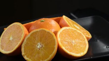 Portakallar siyah tepside yarı yarıya sallanıyor.