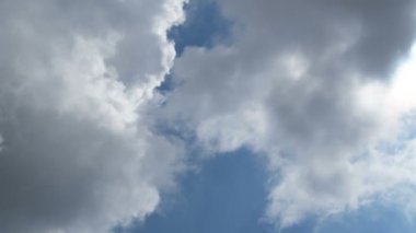 Bulutlar mavi gökyüzünde, güneşin üzerinde hareket ediyor.