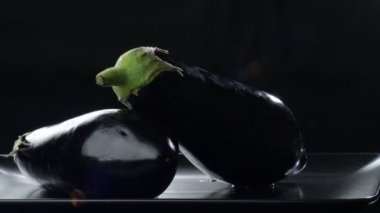 Siyah arka planda dönen doğal patlıcanlar. Solanum Melongena