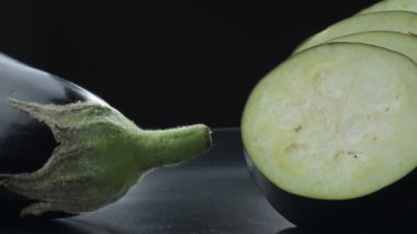Doğal çiğ patlıcan, siyah arka planda sallanırken kesilmiş. Solanum Melongena