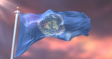 Birleşmiş Milletler bayrağı gün batımında rüzgarda sallanıyor.