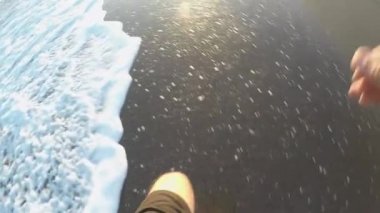 Gün batımında sahilde koşan bir koşucu, birinci şahıs manzaralı.