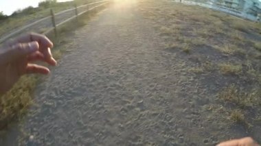 Gün batımında yavaş bir yolda koşan koşucunun öznel görünümü