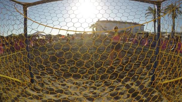 日没時の女性のビーチハンドボールの試合で目標と遊ぶ — ストック動画
