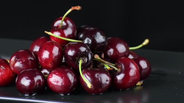 Fruta Cerejas Uma Bandeja Preta Girando Com Fundo Preto — Vídeo de Stock