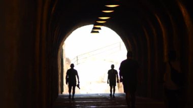 People walking at end of a old tunnel