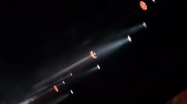 Bir rock konserinde ışıklar dumanla çarpıyor.