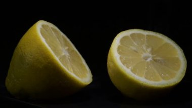 Taze limon kesimi siyah arka planda meyve kıvrımı