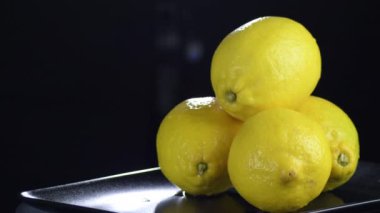 Siyah arkaplanda dönen taze limonlar