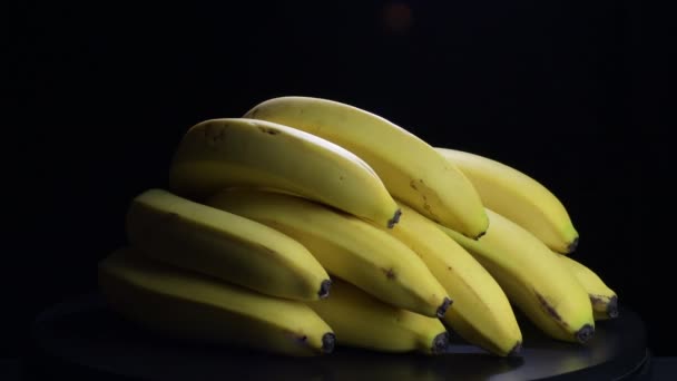 在黑色背景上旋转的香蕉束 — 图库视频影像