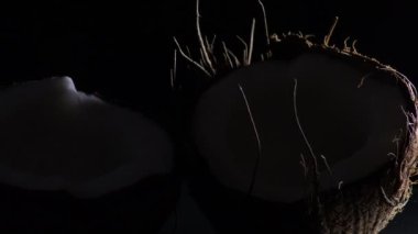 Hindistan cevizi kırığı, tropikal meyve, siyah arka planda, samimi ışık ile