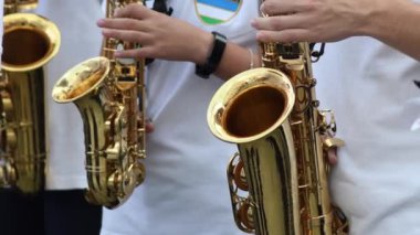 Sokaktaki bir müzik grubunda farklı saksafonlar çalan müzisyenler.