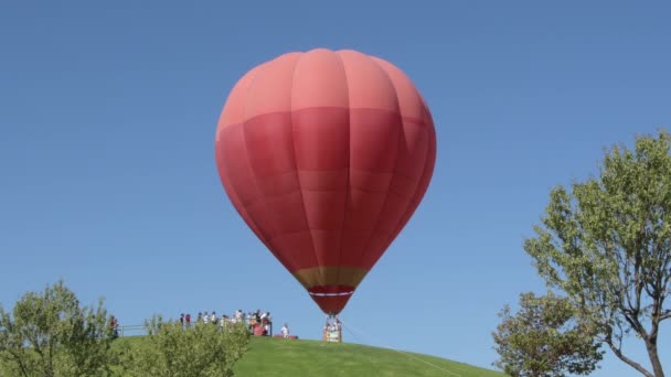 Roter Heißluftballon Startet Mit Reisenden Korb — Stockvideo