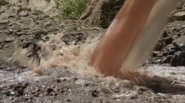 Sewage shit falling from a sewer collector into the mouth of a river