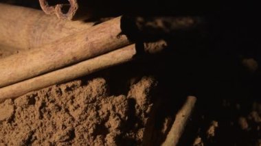 Toz ve sopalar siyah arkaplanda dönüyor