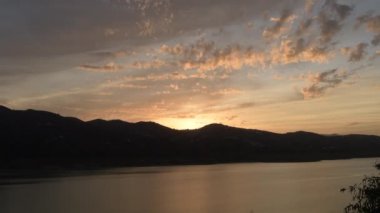 Gölde gün batımı Dağlar ve gökyüzünde bulutlar