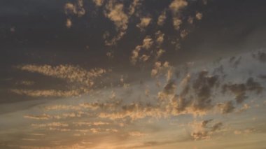 Gün batımında gökyüzünde savrulan bulutlar, zaman akıp gidiyor.