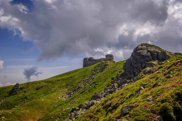 Ruins of the old stone observatory on the mountain peak Pip Ivan of the Chornohora range in the Eastern Carpathians in summer, Ukraine.