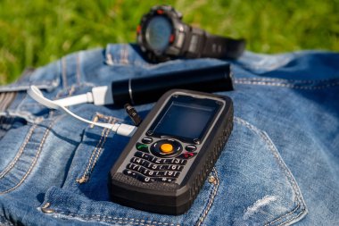 Bir cep telefonu ve bir kot arka plan saati bir güç banka