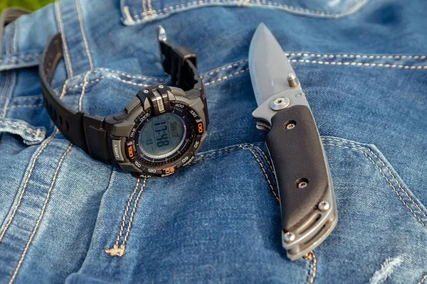 鋭いナイフと自然のジーンズ バック グラウンド上のクロック — ストック写真