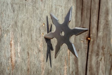 Shuriken (fırlatma yıldızı), geleneksel Japon Ninja soğuk silahı ahşap arka planda sıkışmış